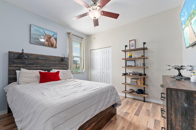 bedroom with light wood-type flooring, a ceiling fan, baseboards, and a closet