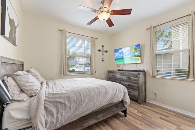 bedroom with ceiling fan, baseboards, and wood finished floors