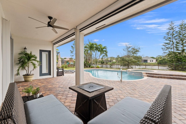 view of swimming pool featuring a patio, a pool with connected hot tub, fence, and a ceiling fan