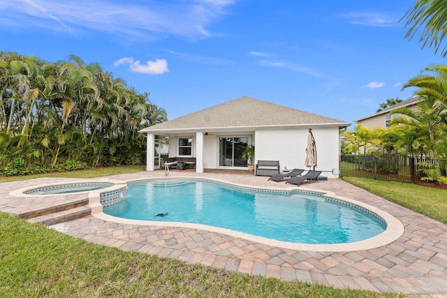 view of pool featuring a patio area, a pool with connected hot tub, and fence