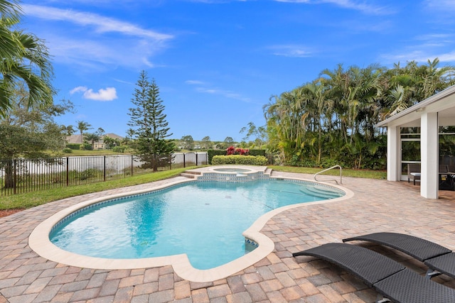 view of pool featuring a water view, a pool with connected hot tub, fence, and a patio