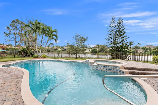 view of pool featuring fence and a pool with connected hot tub