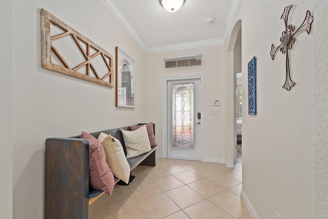 entryway with baseboards, visible vents, arched walkways, crown molding, and light tile patterned flooring