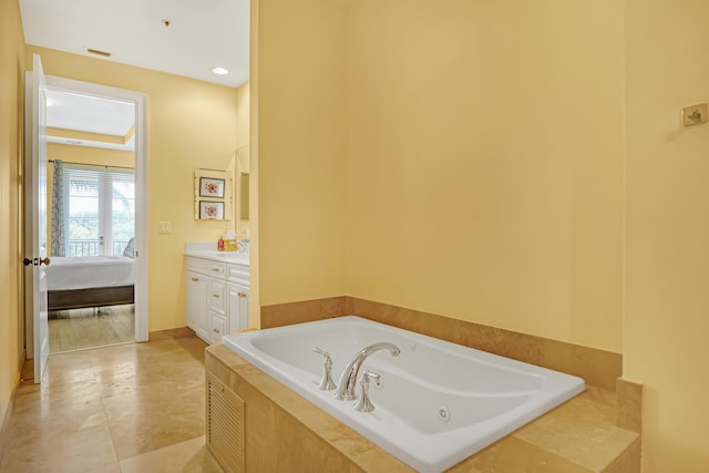 ensuite bathroom with tile patterned floors, ensuite bath, vanity, and a bath