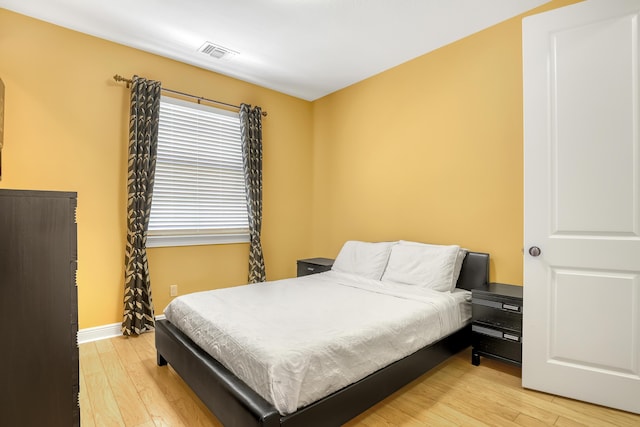 bedroom featuring visible vents, baseboards, and light wood-style floors