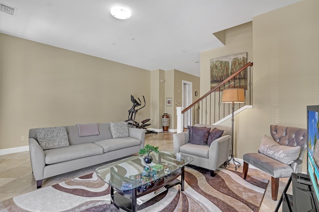 living area featuring stairs, baseboards, and visible vents