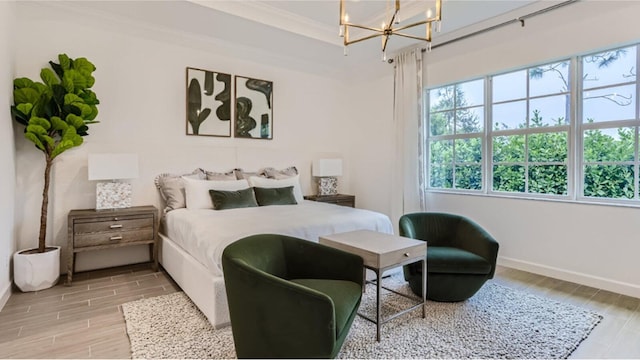 bedroom with an inviting chandelier, baseboards, ornamental molding, and wood finish floors