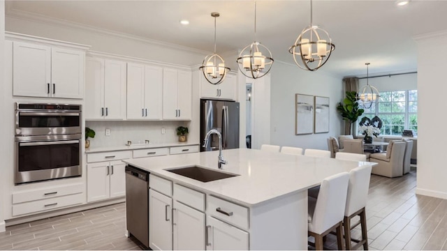 kitchen featuring stainless steel appliances, wood tiled floor, a sink, and ornamental molding