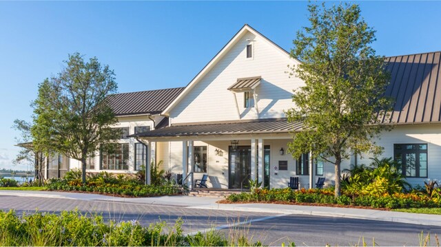 view of front of house featuring a standing seam roof, a porch, and metal roof