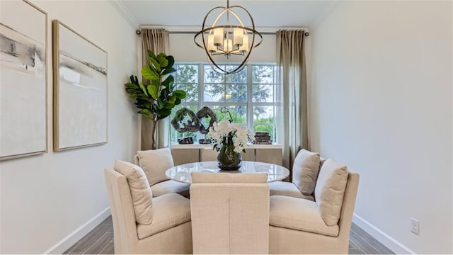 dining space featuring crown molding, baseboards, a notable chandelier, and wood finished floors