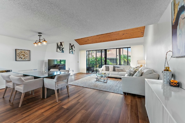 living room with a textured ceiling, a notable chandelier, baseboards, vaulted ceiling, and dark wood finished floors