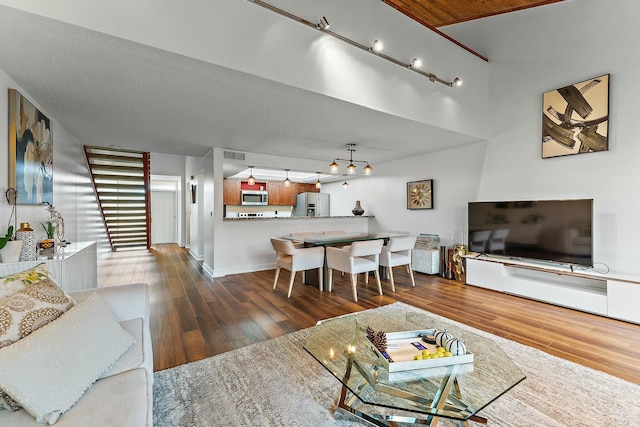 living room featuring baseboards, visible vents, and wood finished floors