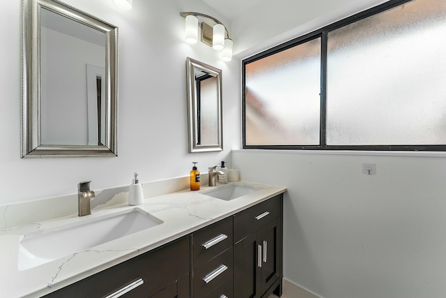 full bathroom with double vanity and a sink