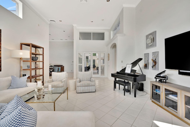 living area featuring visible vents, crown molding, light tile patterned floors, a towering ceiling, and arched walkways