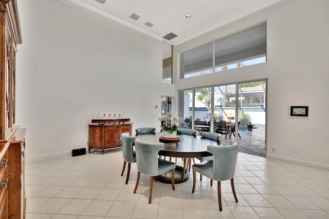 dining area featuring baseboards, light tile patterned flooring, and ornamental molding