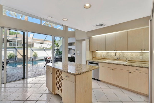 kitchen featuring light brown cabinets, visible vents, dishwasher, and a sink