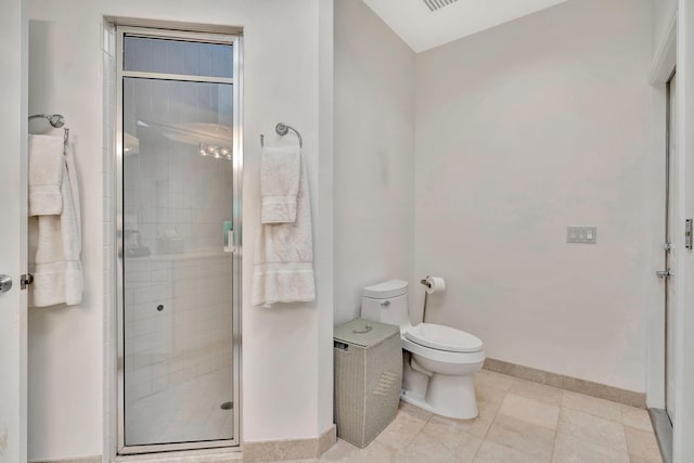 full bathroom featuring baseboards, toilet, a stall shower, and tile patterned flooring