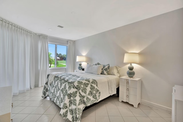 bedroom featuring light tile patterned floors, visible vents, and baseboards