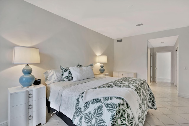 bedroom featuring light tile patterned floors, visible vents, and baseboards