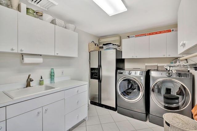 washroom with washer and dryer, cabinet space, light tile patterned floors, and a sink