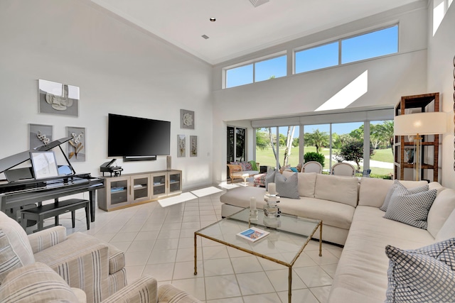 tiled living area with visible vents, crown molding, and a towering ceiling