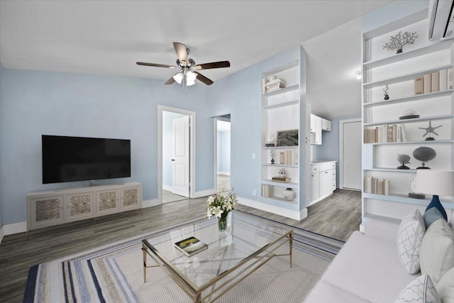 living room with ceiling fan, baseboards, and wood finished floors