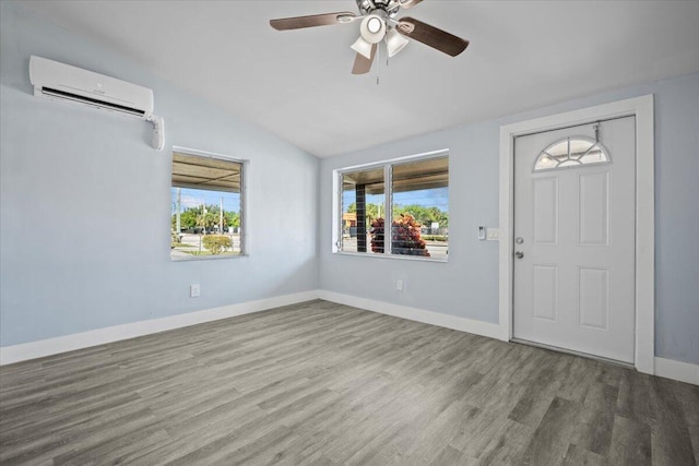 entrance foyer featuring baseboards, a ceiling fan, wood finished floors, vaulted ceiling, and a wall mounted AC