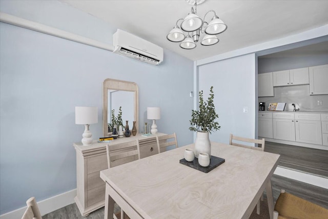 dining area featuring baseboards, an AC wall unit, dark wood finished floors, and an inviting chandelier