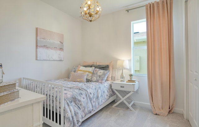 carpeted bedroom with baseboards and an inviting chandelier