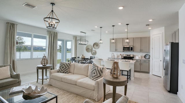 living area with a water view, visible vents, a chandelier, and recessed lighting