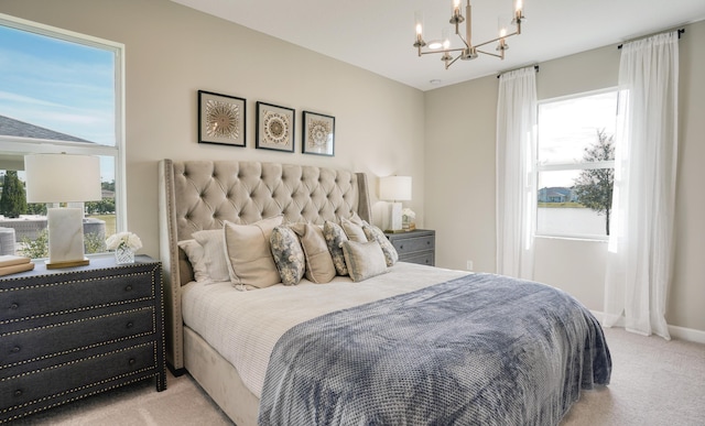 carpeted bedroom featuring multiple windows, baseboards, and an inviting chandelier