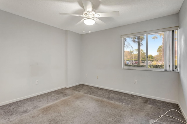 carpeted spare room featuring a ceiling fan, a textured ceiling, and baseboards