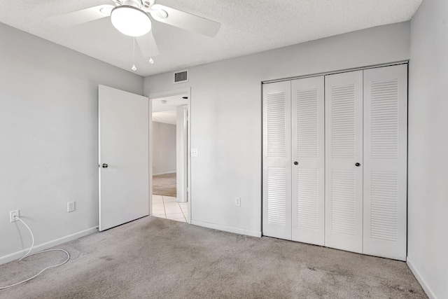 unfurnished bedroom featuring carpet floors, a closet, visible vents, a textured ceiling, and baseboards