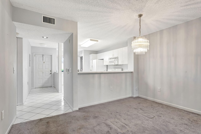 kitchen with white appliances, visible vents, light colored carpet, a textured ceiling, and white cabinetry