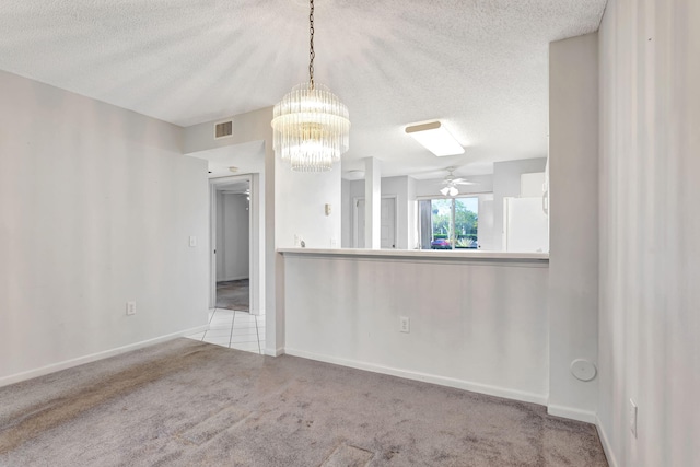 carpeted spare room with a textured ceiling, visible vents, and baseboards