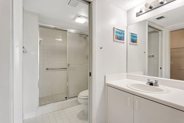 full bath featuring a shower stall, visible vents, a textured ceiling, and toilet