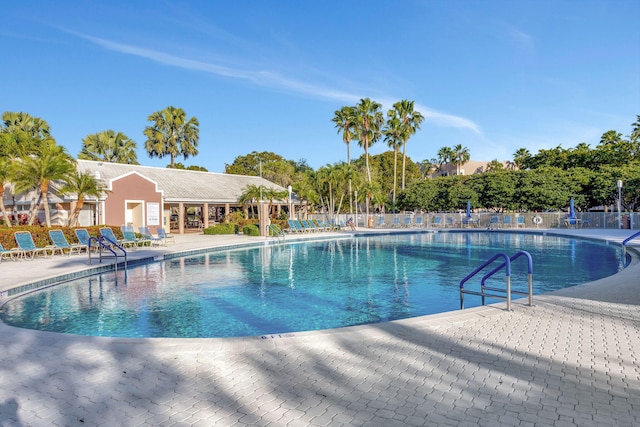 pool with a patio area and fence