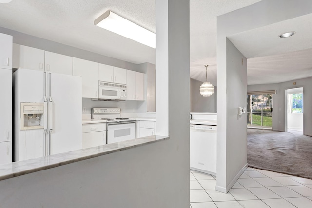 kitchen featuring light tile patterned floors, white cabinets, light carpet, white appliances, and baseboards