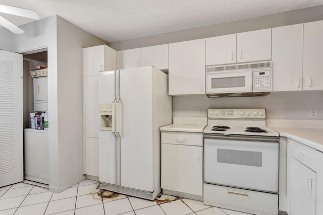 kitchen with white appliances, stacked washer / drying machine, light countertops, a textured ceiling, and white cabinetry