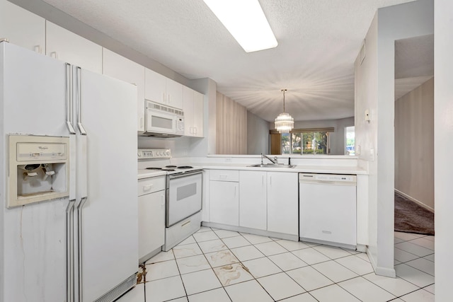 kitchen with white appliances, light countertops, white cabinetry, pendant lighting, and a sink