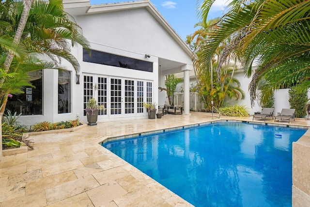 pool with a patio area, french doors, and fence