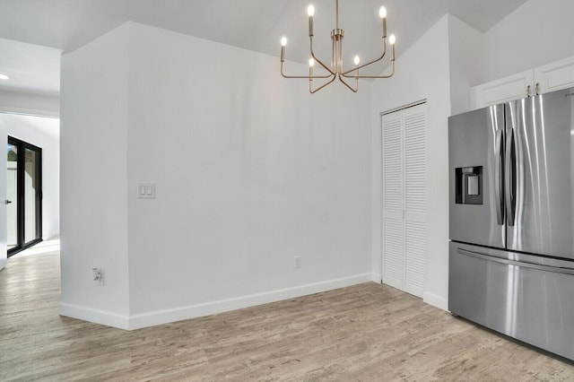 kitchen featuring baseboards, light wood-type flooring, an inviting chandelier, and stainless steel fridge with ice dispenser