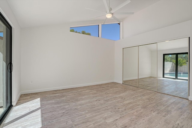 unfurnished bedroom featuring baseboards, light wood-style floors, a closet, a ceiling fan, and access to outside