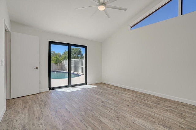 unfurnished room with a ceiling fan, lofted ceiling, wood finished floors, and baseboards