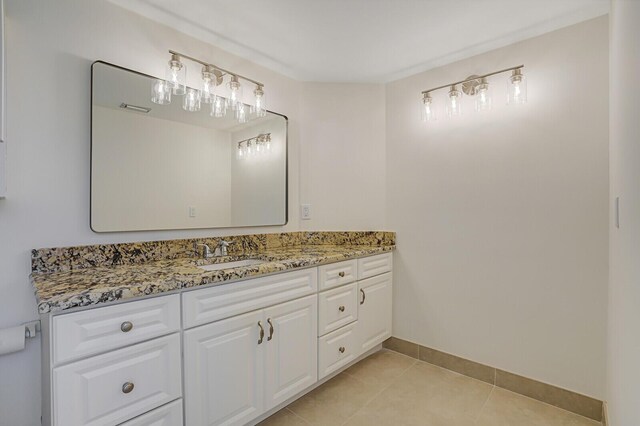 bathroom featuring tile patterned flooring, vanity, and baseboards