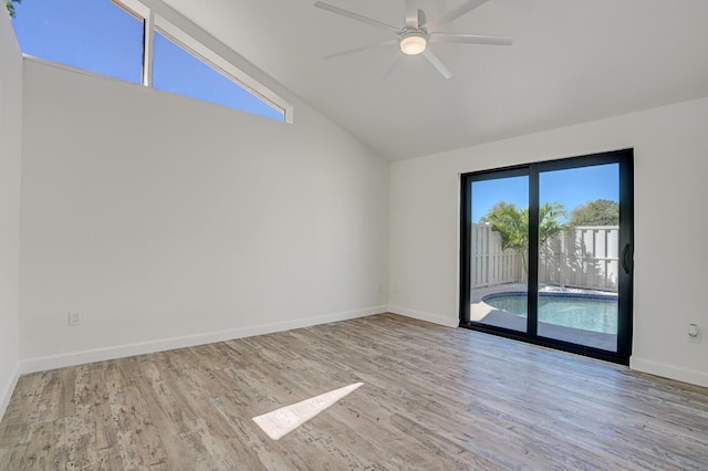 empty room featuring ceiling fan, baseboards, wood finished floors, and vaulted ceiling