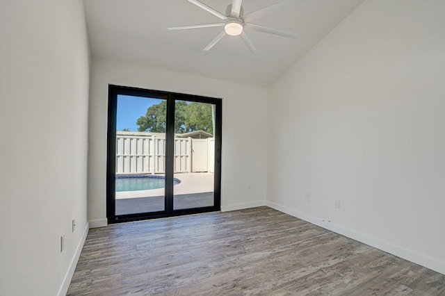 unfurnished room with lofted ceiling, baseboards, and wood finished floors