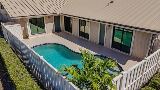 pool with a fenced backyard and a patio