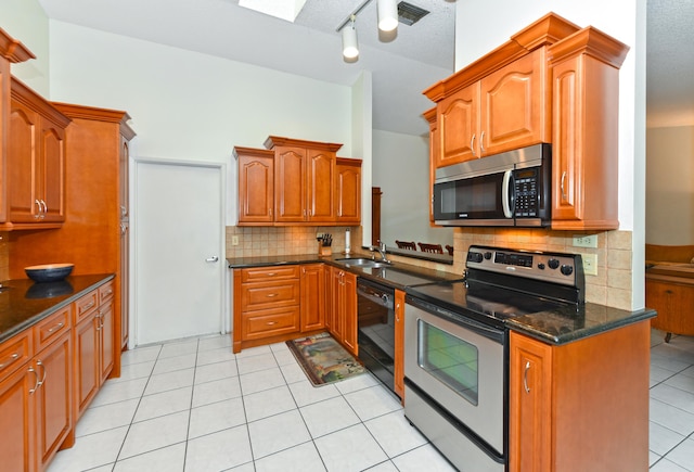 kitchen with visible vents, a sink, stainless steel appliances, backsplash, and light tile patterned flooring