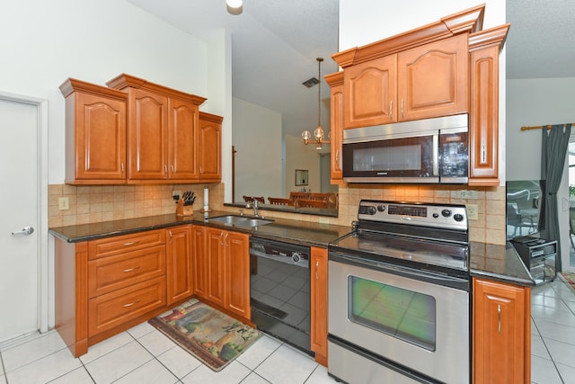 kitchen with appliances with stainless steel finishes, light tile patterned flooring, a sink, and tasteful backsplash